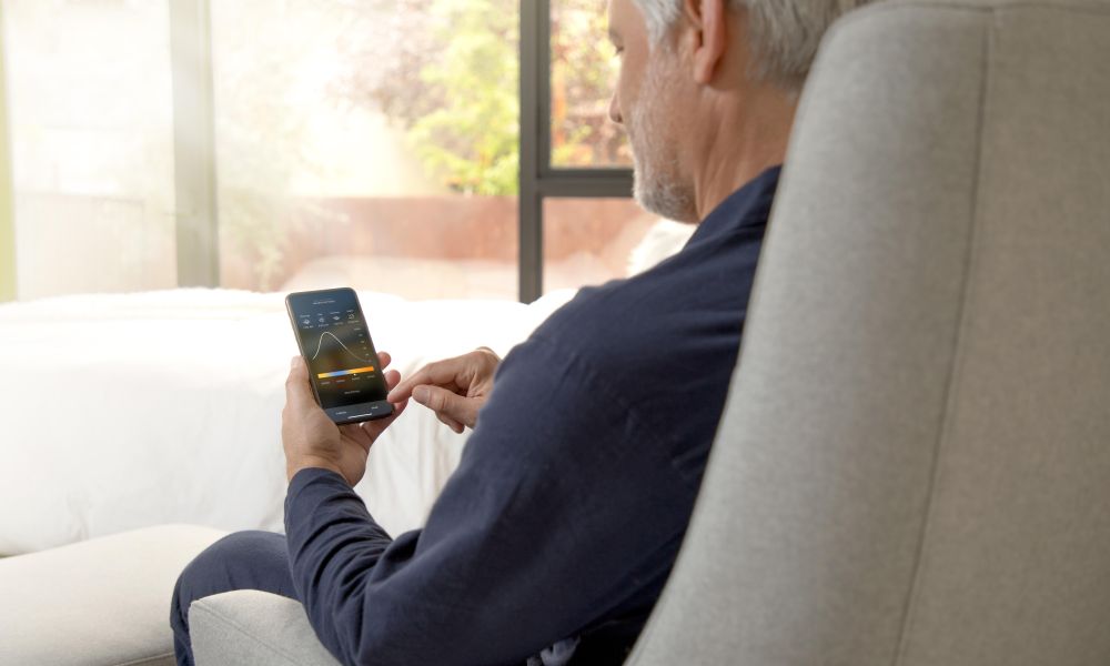 Man holding a phone looking at a Savant Power app screen