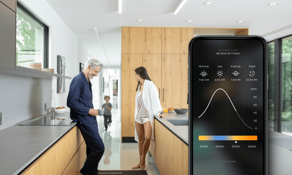 Family in a modern kitchen. iPhone on the front with a Savant Power App screen